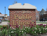 the sign of the city of Pella Public Library surrounded in tulips